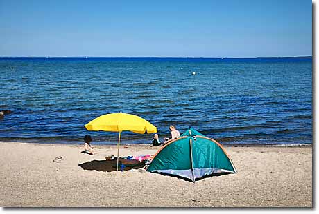 Ostseestrand Ohrfeldhaff in Niesgrau Urlauber mit gelbem Sonnenschirm und grüner Strandmuschel am Sandstrand in Ohrfeldhaff an der Ostsee